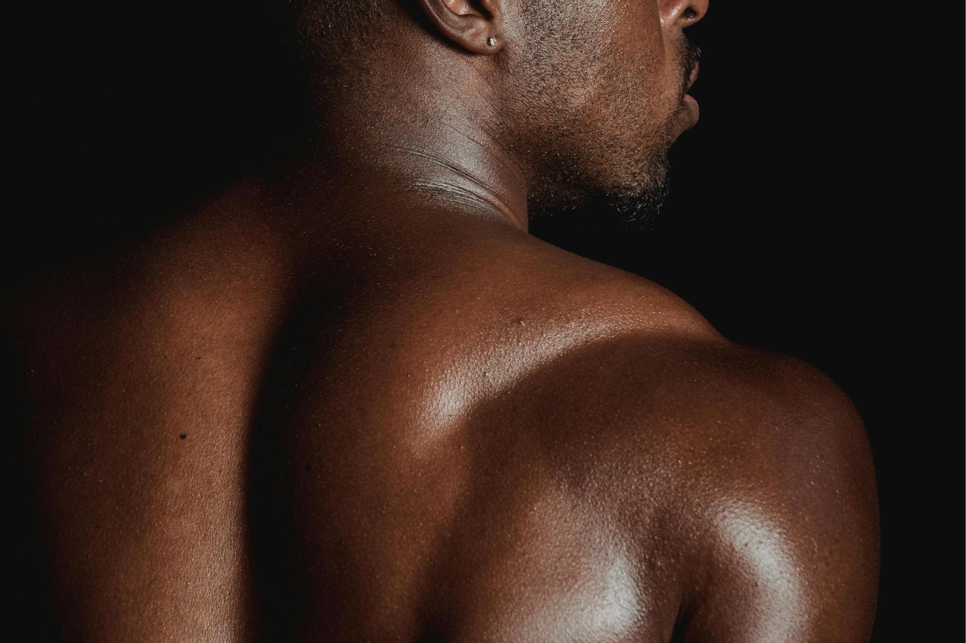 A powerful studio shot showcasing the muscular back of an African male model.