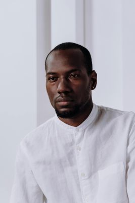 Serious business portrait of a man in a white shirt with minimalist background.